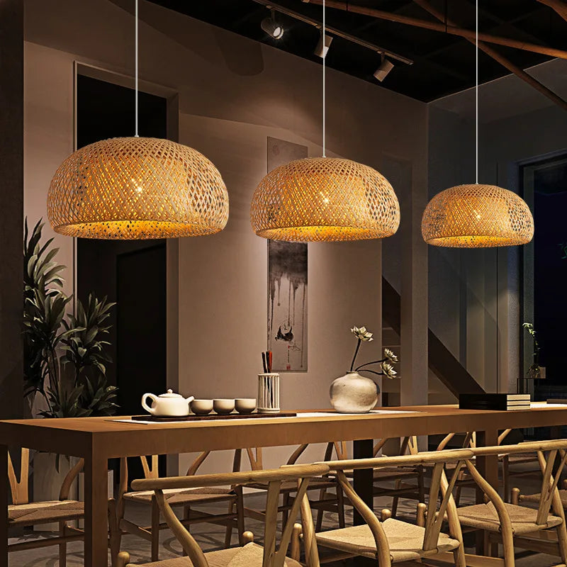 Three ZenWeave 'Tiered Serenity' bamboo pendants hanging over a modern sushi bar, casting a warm, inviting light and creating an authentic, serene oriental atmosphere. VelunaLumin.