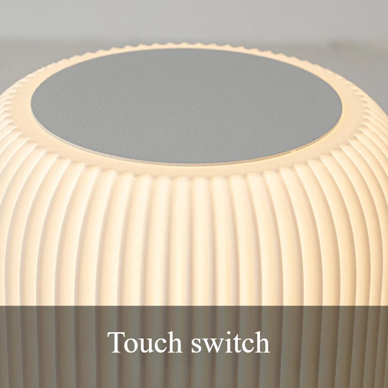 Close-up of a hand touching the AuraShroom lamp to adjust its brightness, showcasing the intuitive touch control. VelunaLumin.