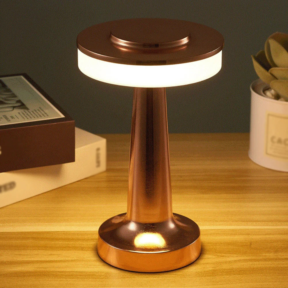 Close-up of a hand touching the top of the AuraGlow Cordless Touch Lamp to adjust brightness and light color. VelunaLumin.