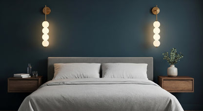 AuraBeam Linear Wall Sconce in Gold mounted beside a bed, providing a sophisticated and warm ambient glow in a contemporary bedroom. VelunaLumin.