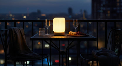 AuraShroom Cordless Lamp illuminating an outdoor patio table at dusk, highlighting its portable and rechargeable design. VelunaLumin.
