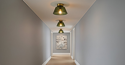 A series of AuraSphere Ceiling Lights in mixed Amber, Green, and Transparent glass illuminating a minimalist hallway, creating a rhythmic and sophisticated path of light. VelunaLumin