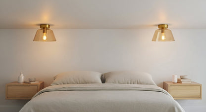 Two AuraSphere Ceiling Lights in a soft Amber glass finish, symmetrically mounted on the ceiling on either side of a bed in a serene bedroom. VelunaLumin.