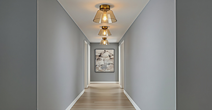 A series of AuraSphere Ceiling Lights in mixed Amber, Green, and Transparent glass illuminating a minimalist hallway, creating a rhythmic and sophisticated path of light. VelunaLumin