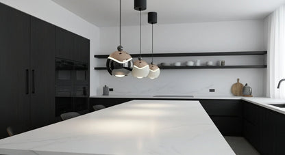 A cluster of AuraSpire pendants in Black and Off-White hanging over a modern white marble kitchen island, providing focused LED light. VelunaLumin.