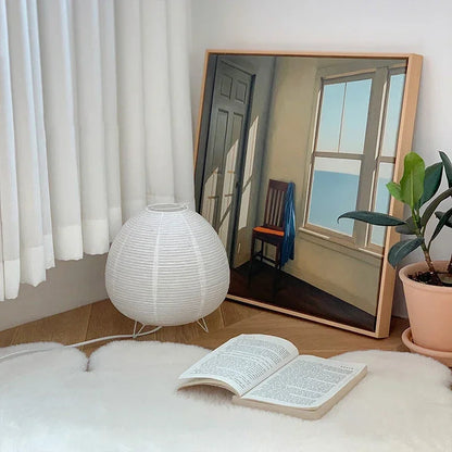 Akari Rice Paper Table Lamp on a minimalist bedside table, providing a serene and cozy ambient light in a modern Japandi-style bedroom. VelunaLumin.