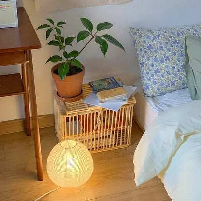 Akari Rice Paper Table Lamp on a minimalist bedside table, providing a serene and cozy ambient light in a modern Japandi-style bedroom. VelunaLumin.