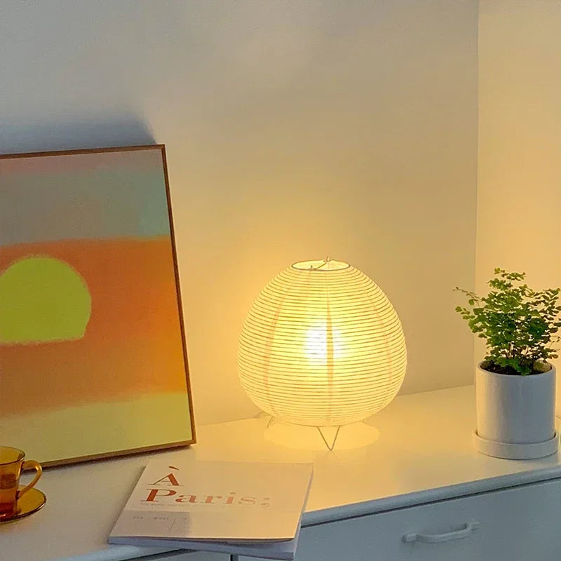 Akari Rice Paper Table Lamp with a sculptural, organic design inspired by Japanese Wabi-Sabi aesthetics, casting a warm, diffused light. VelunaLumin.