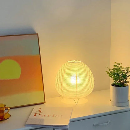 Akari Rice Paper Table Lamp with a sculptural, organic design inspired by Japanese Wabi-Sabi aesthetics, casting a warm, diffused light. VelunaLumin.