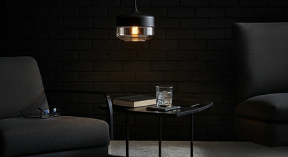 LuminaGrace Rich Amber & Clear Glass Slim Cylinder Pendant Light hanging above a velvet bedside table, casting a warm, intimate glow in a luxurious bedroom setting, VelunaLumin.