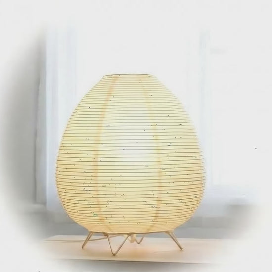 Akari Rice Paper Table Lamp with a sculptural, organic design inspired by Japanese Wabi-Sabi aesthetics, casting a warm, diffused light. VelunaLumin.